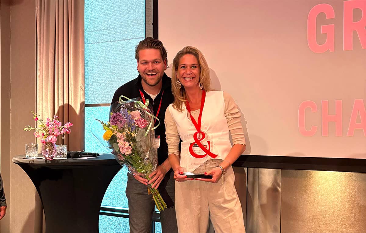 Man met bloemen in de hand en vrouw met ketting om met &-teken.